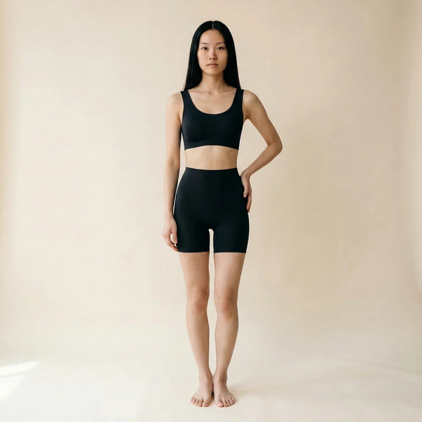 Panty gainant invisible femme — vue de face, short mi-cuisse seamless noir, taille haute anti-démarcation