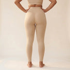 Legging sculptant ventre plat beige Elya vue de dos, mains sur les hanches — galbe et maintien, taille haute seamless