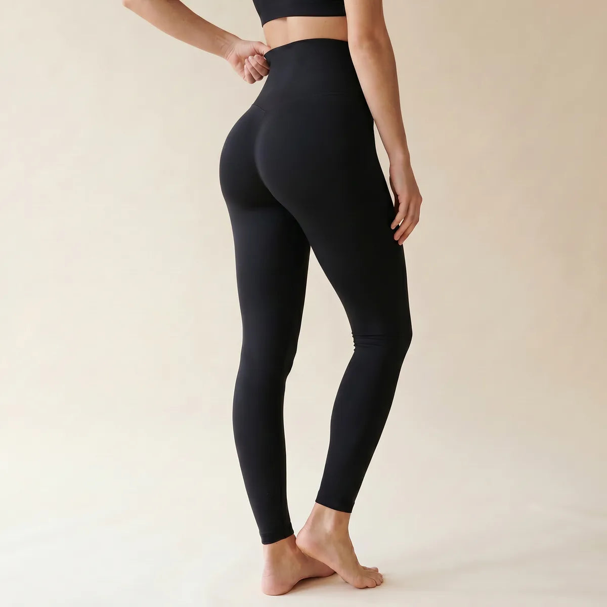Legging taille haute gainant noir Elya vue de dos trois-quarts — ceinture sous la poitrine et fessier galbé