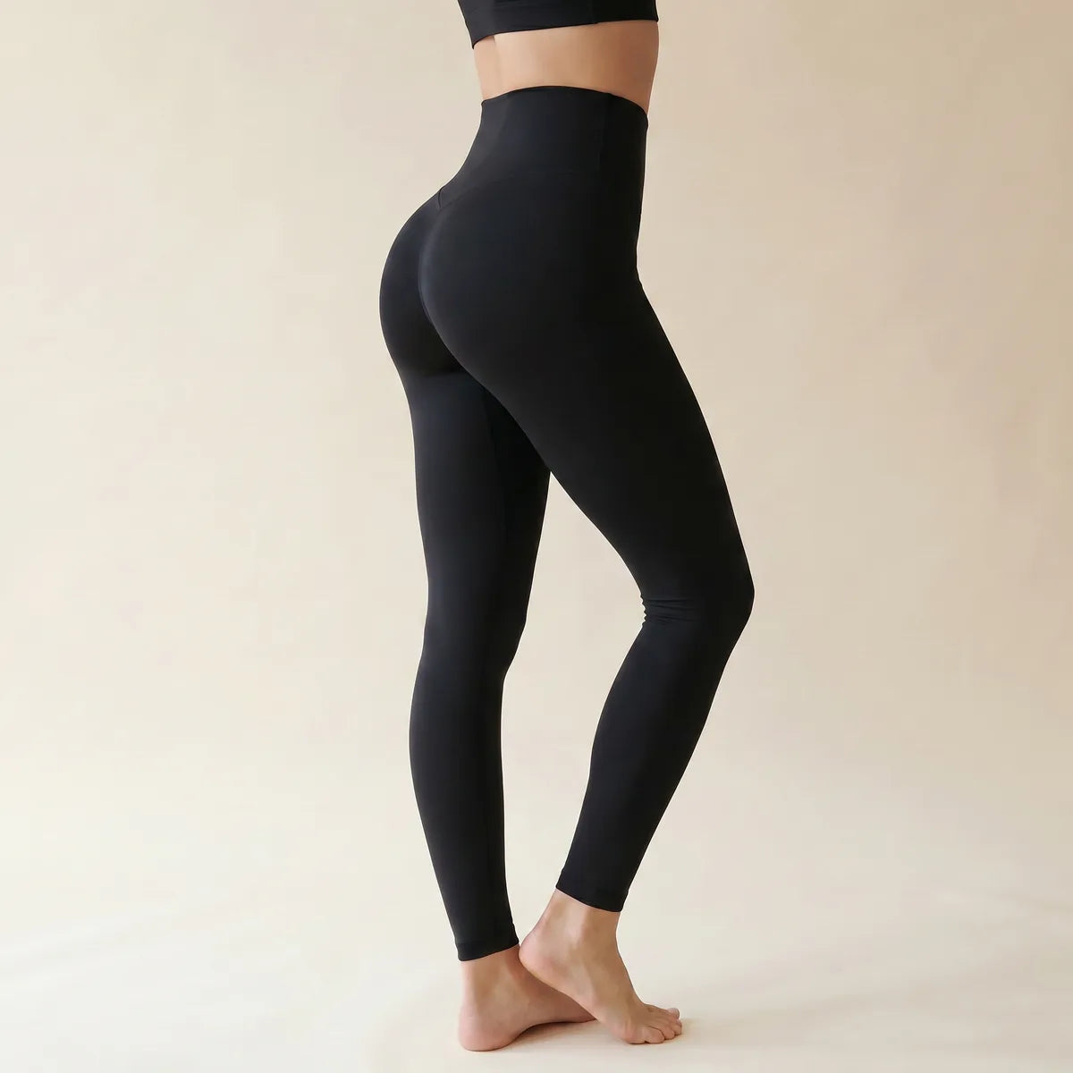 Legging taille haute gainant noir Elya vue de profil — ceinture extra-haute qui marque la taille, maille seamless
